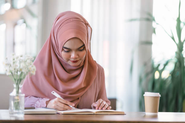 istock An Asian Muslim university student is doing homework at home. 1864617766