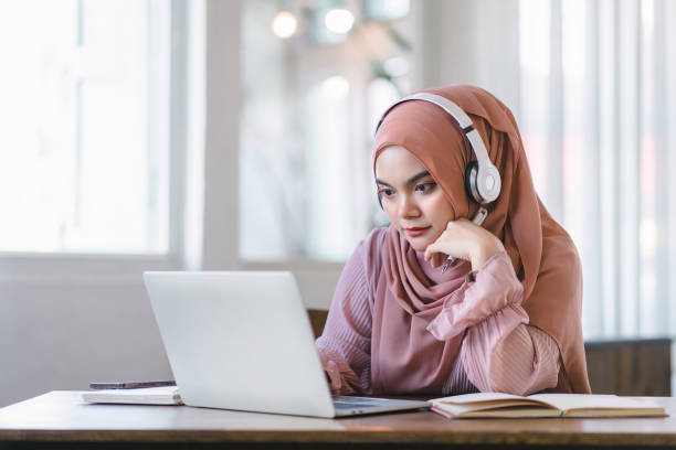 istock Asian Muslim university student studying remotely, using laptop and listening to online lecture. 1864618209