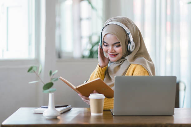 istock An Asian Muslim university student relaxes while reading a book at home. 1864618304