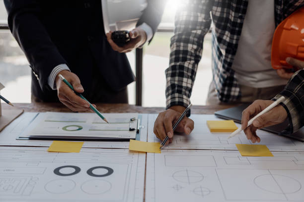 istock Engineering teams work in blueprint meetings for the project, working with partners to create engineering models and tools. Close-up pictures construction concept 1864633522