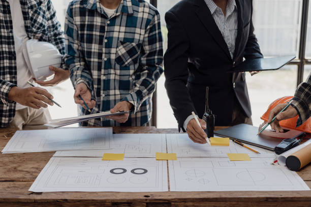 istock Engineering teams work in blueprint meetings for the project, working with partners to create engineering models and tools. Close-up pictures construction concept 1864633523