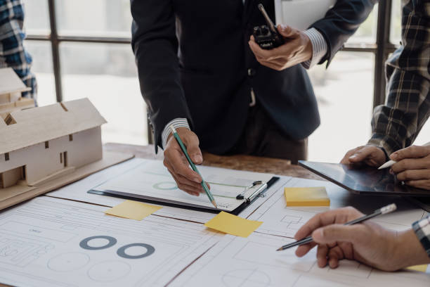 istock Engineering teams work in blueprint meetings for the project, working with partners to create engineering models and tools. Close-up pictures construction concept 1864633524