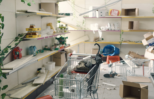 Destroyed post-apocalyptic supermarket interior with empty broken shelves: crisis, war and catastrophes concept