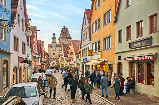Rothenburg ob der Tauber, Germany - December 16, 2023: Pedestrians walk through the medieval streets of Rothenburg in winter.