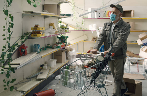istock Man doing grocery shopping in a destroyed supermarket interior 1864641139