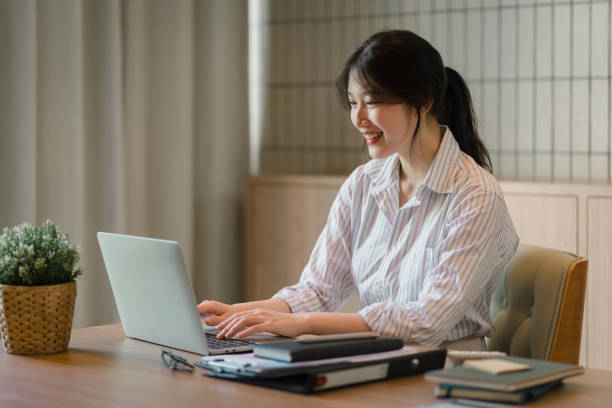 istock Smiling young asian businesswoman using laptop to work online, remote work. 1864644438