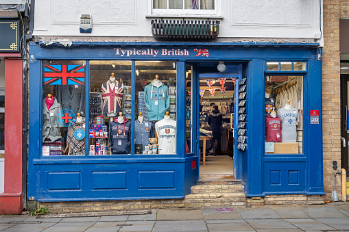 Bridge Street, Cambridge, England - November 9th 2023:  English souvenir shop on the sunny side of main street in the famous university city