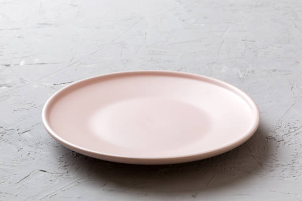 istock Perspective view of empty pink plate on cement background. Empty space for your design 1864665879