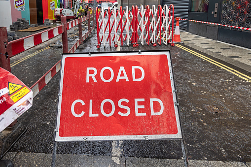 Charing Cross Road, London, England - November 8th 2023:  Sign saying road closed, due to construction work construction barriers
