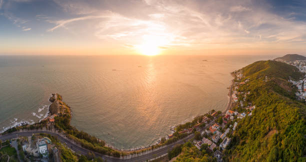 Panoramic coastal Vung Tau view from above, with waves, coastline, streets, coconut trees, Mount Nho in Vietnam behind the statue of Christ the King. Travel and landscape concept