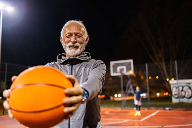 istock Senior Man Holding a Basketball Ball 1864686719