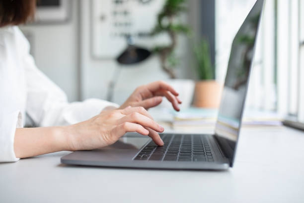 istock Unrecognizable lady working with laptop and typing on computer keyboard, sitting at coworking space, cropped closeup 1864687120