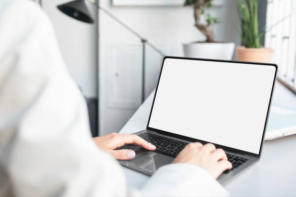 istock Unrecognizable businesswoman using laptop computer with white blank screen, mockup for ad, website design, copy space 1864687165