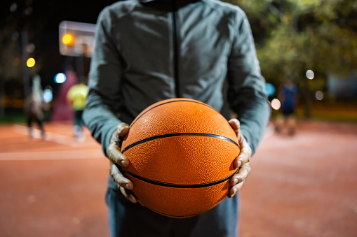 Close-up of man with basketball ball at sports field