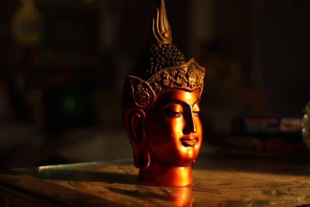 istock A Red and brown colored Buddha Statue or figurine in golden hour sunlight with selective focus, facing light 1864691575