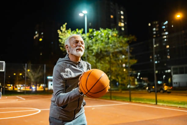 istock Senior man aiming at basketball hoop. 1864693222