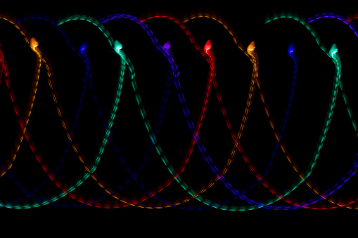 Multi-colored Christmas lights create brightly colored vibrant light trails when taken with a slower shutter speed and moving the camera.