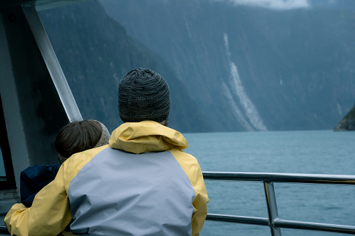 Young couple watching waterfalls at  Milford Sound Fiordland National Park
