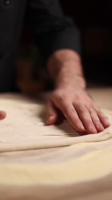 Pizzaiolo kneading pizza dough with his hands