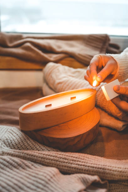 istock A match lights a candle in wood, stylish interior 1864722798