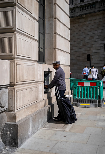 A man using an ATM in the City of London.