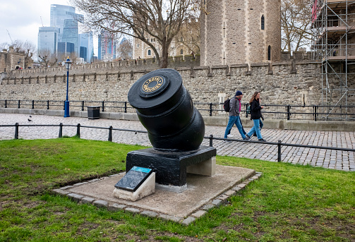 An old mortar gun mounted on Tower Wharf outside the Tower of London. It is possibly Spanish or French and from the mid-18th century: it belongs to the Royal Armouries collection. Some of the skyscrapers of the City of London are seen in the lefthand background.