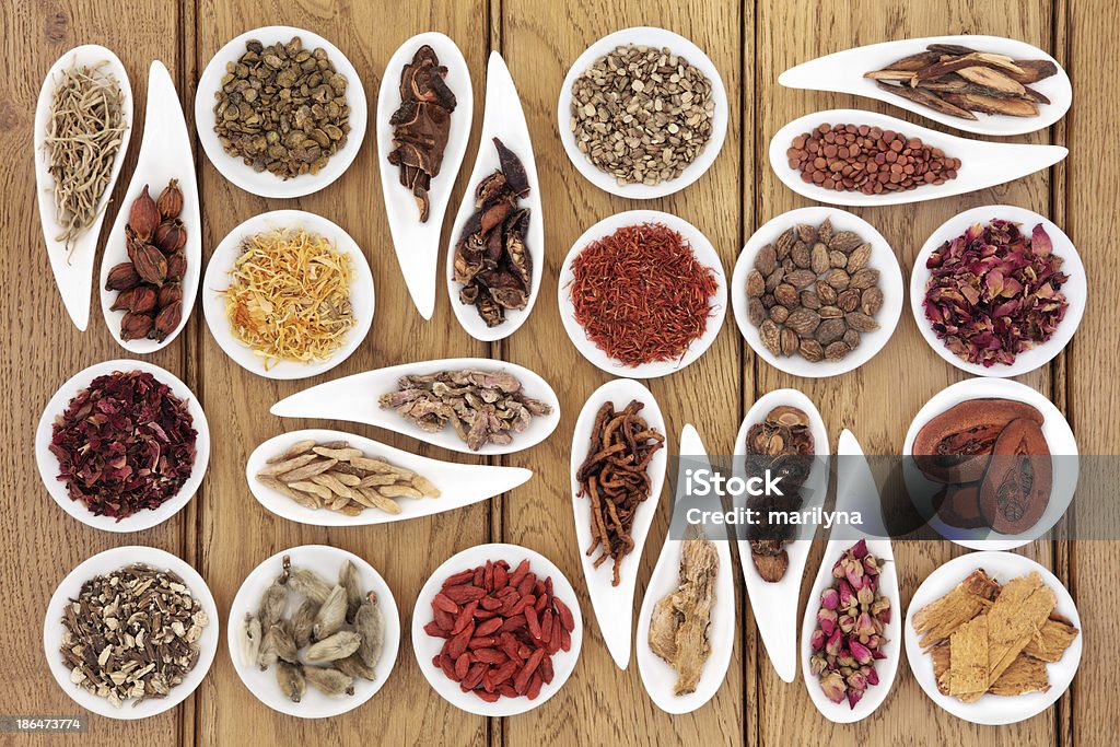 Traditional Chinese Medicine Large chinese herbal medicine selection in white porcelain dishes over oak background. Alternative Medicine Stock Photo