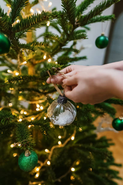 istock Woman hangs a ball on a New Year tree. 1864744927