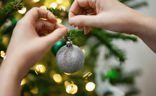 istock Woman hangs a ball on a New Year tree. 1864744932