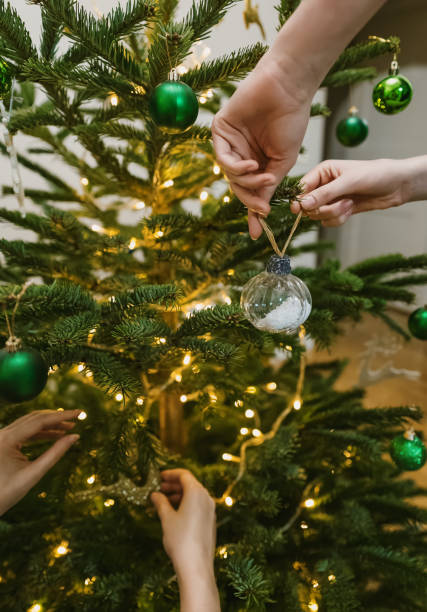 istock Women hangs a balls on a New Year tree. 1864744933
