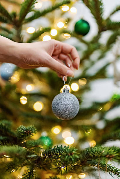 istock Woman hangs a ball on a New Year tree. 1864744934