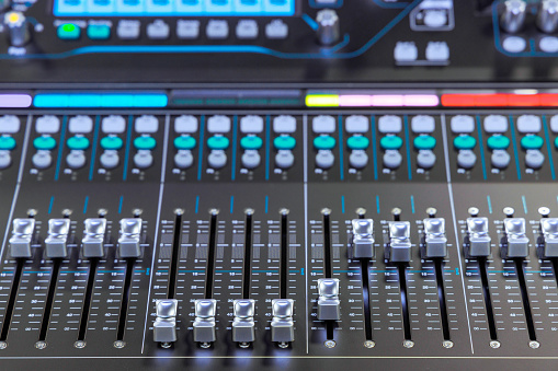 Close-up on the rows of buttons from a mixing board.