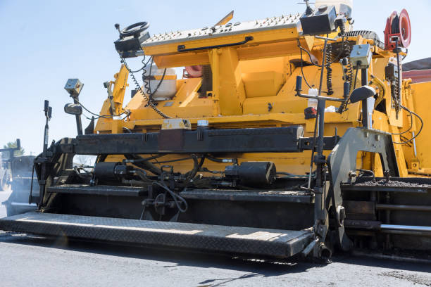 istock During highway construction, a pavement machine lays fresh bitumen asphalt over gravel base 1864782255