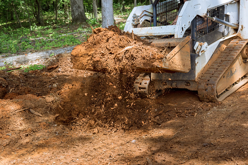 dirty skid loader or bobcat with metal tracks on rubber tires