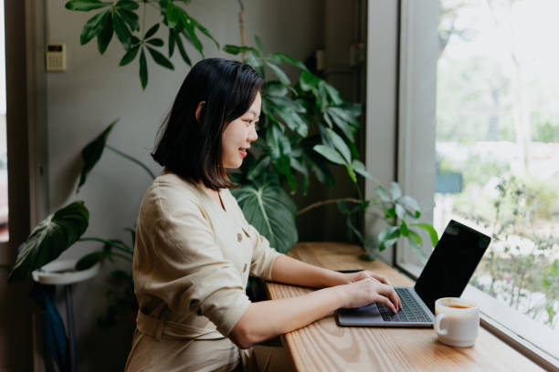 istock Asian woman working on laptop in cafe 1864822404