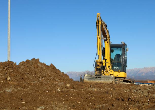 istock Compact excavator on heap of dirt in a new housing development area. 1864829429