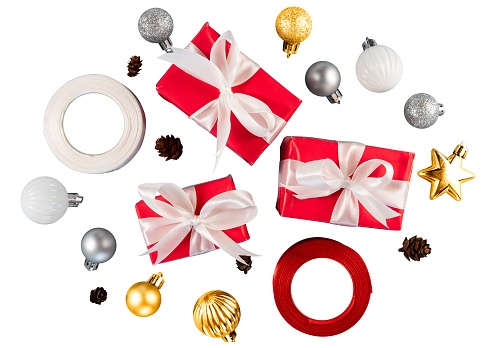 Front view of a square shaped Christmas gift box wrapped with brown craft paper shot on white background. The gift box is tied up with a golden bow. Predominant colors are brown and white.