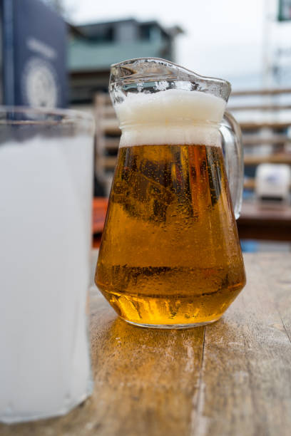 istock Beer in a glass jar with hand holding. Cold beer for the summer 1864853665