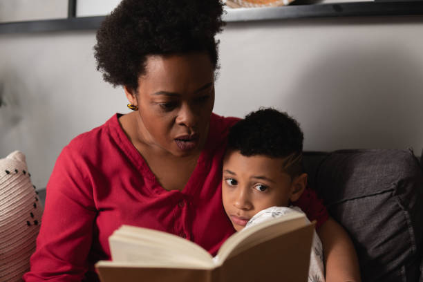 istock Mother with son read book in home room 1864861365