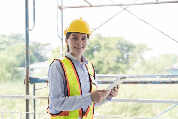 istock Foreman builder woman at construction site. Foreman construction woman working at construction site, wearing safety uniform, helmet and holding digital tablet 1864862440