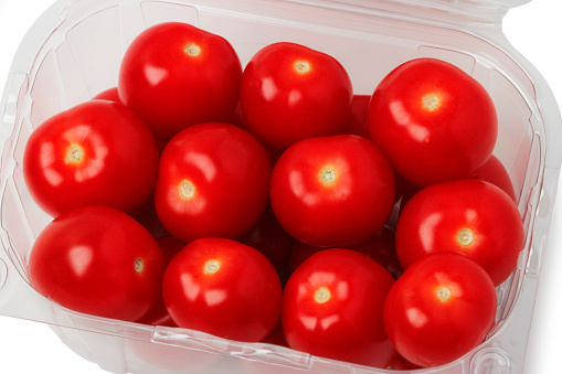 Fresh cherry tomatoes in a plastic disposable container isolated on a white background. View from above