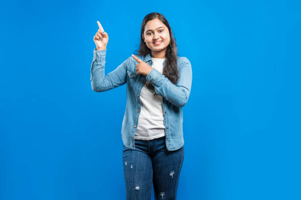 istock Happy Indian women indicating upwards with fore fingers 1864866697