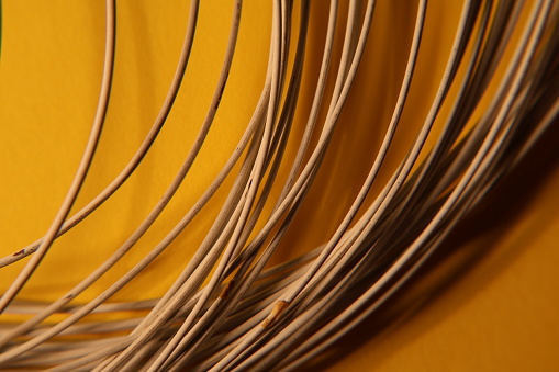 Cable in cable factory, close up. Iron wire with orange background.