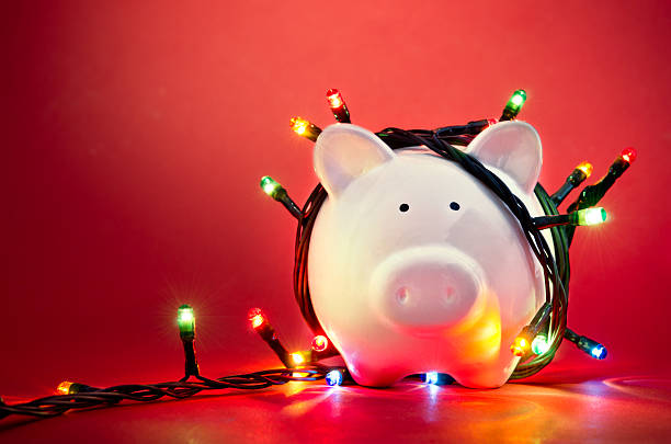 Christmas piggy bank Piggy bank wrapped in Christmas string lights december stock pictures, royalty-free photos & images