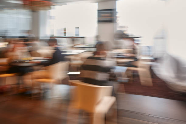 Motion effect in photography. Slow time exposure. Indoor restaurant. People
