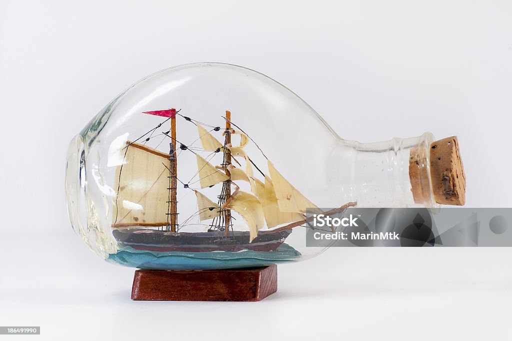 Miniature ship inside a bottle Handmade miniature ship inside a bottle,  on white background. Art Stock Photo