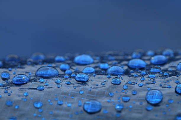 Water drops collecting on the surface of a blue tarp.