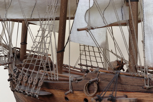 It's a closeup of the bow with the bowsprit, deck, rudder, railing, anchor, rope ladder and sails