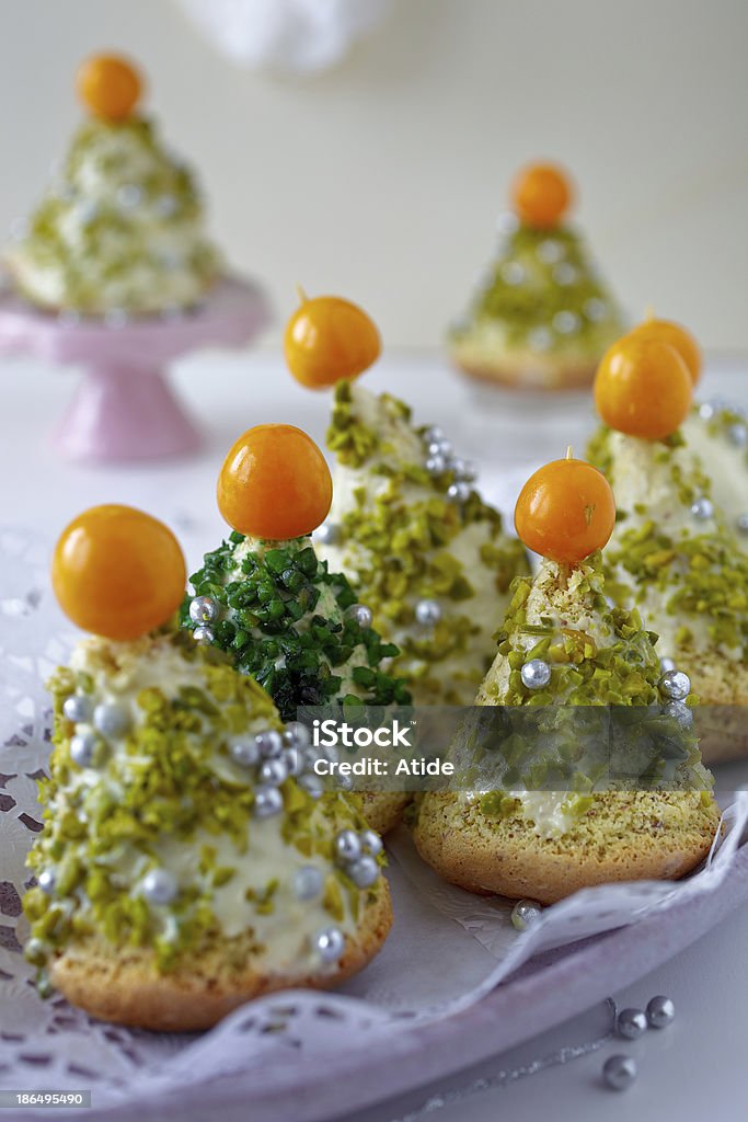 Christmas Tree Cake Cake dipped in a white chocolate and decorated with chips,physalis and pistachio Baked Pastry Item Stock Photo