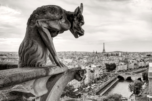 Chimera (gargoyle) of the Cathedral of Notre Dame de Paris overlooking the Eiffel Tower in Paris, France